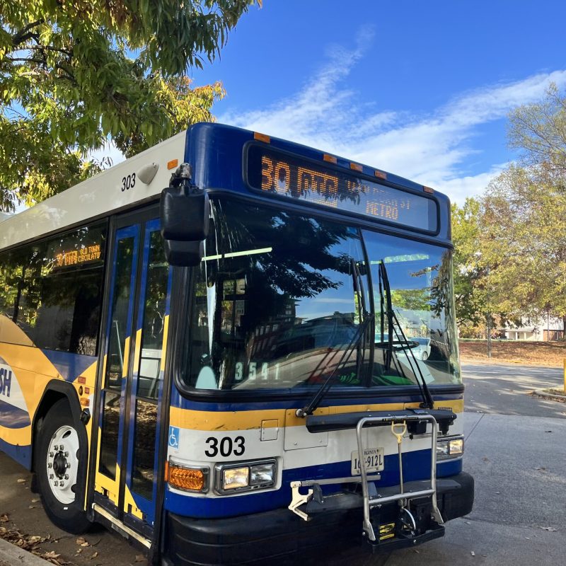 停在一條安靜的街道旁邊的公共巴士的照片圖像。